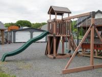 Busy Base Camp Play Set in Woodgrain Brown Vinyl with Green Slides and Swings